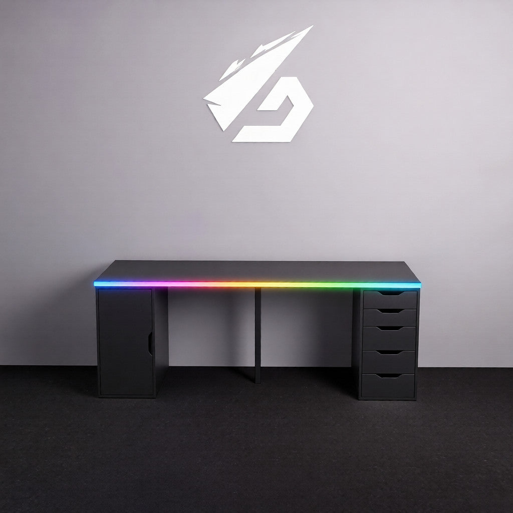 Black gaming desk with RGB lighting under a gray wall featuring a logo.