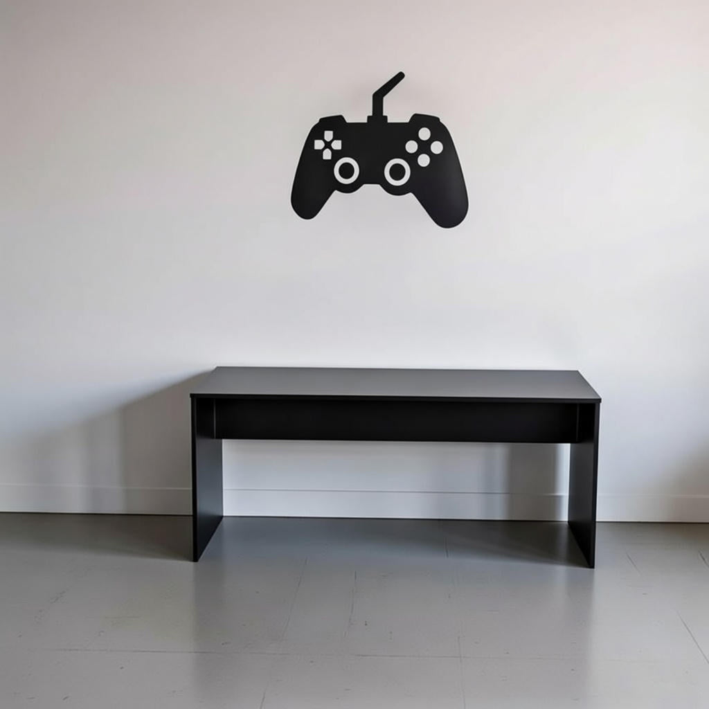 Black gaming controller wall decal above a black desk on a white wall.