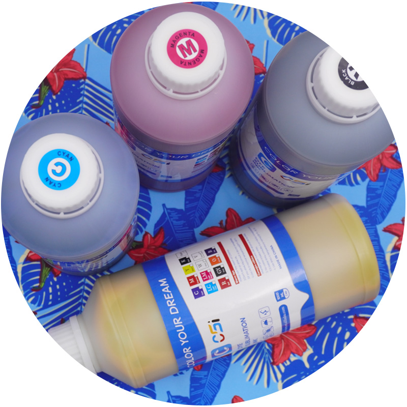 Four ink bottles with colorful labels on a blue floral background