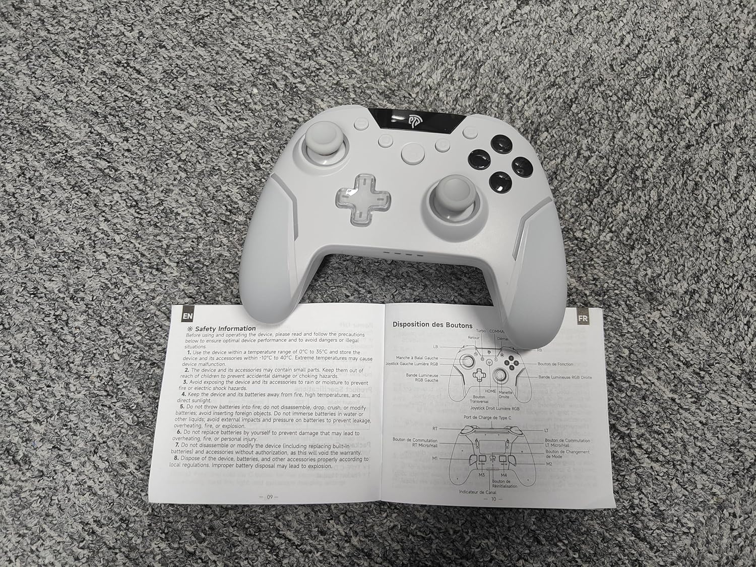 White gaming controller on an open manual on a textured surface