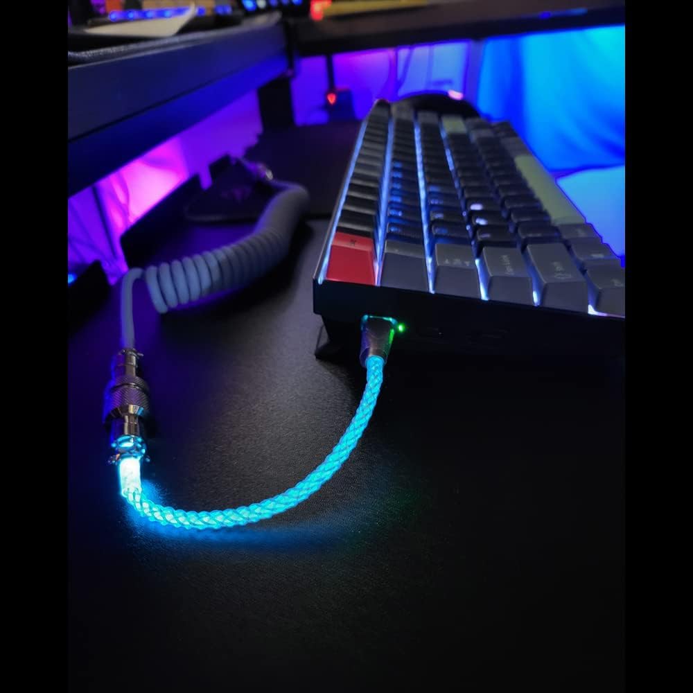 Glowing blue cable connected to a keyboard on a dark surface with colorful lighting in the background.
