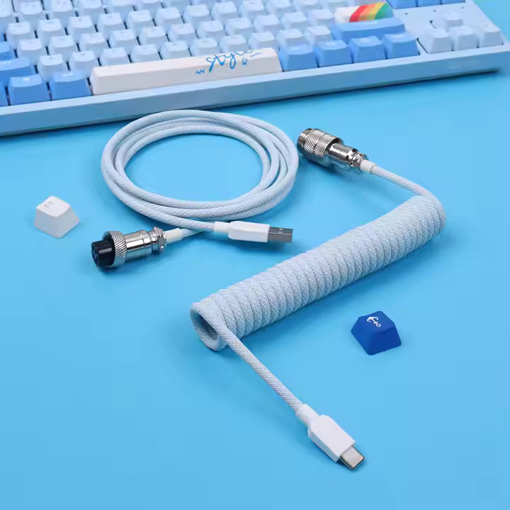 Macaron Coiled cable with connectors on a blue surface with a keyboard in the background