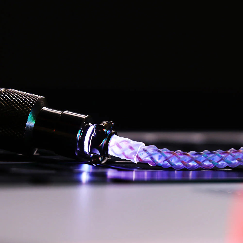 Close-up of a braided cable with a metallic connector on a dark background