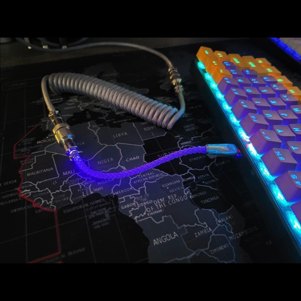 Coiled cable with a USB connector on a map of Africa, next to a colorful keyboard.