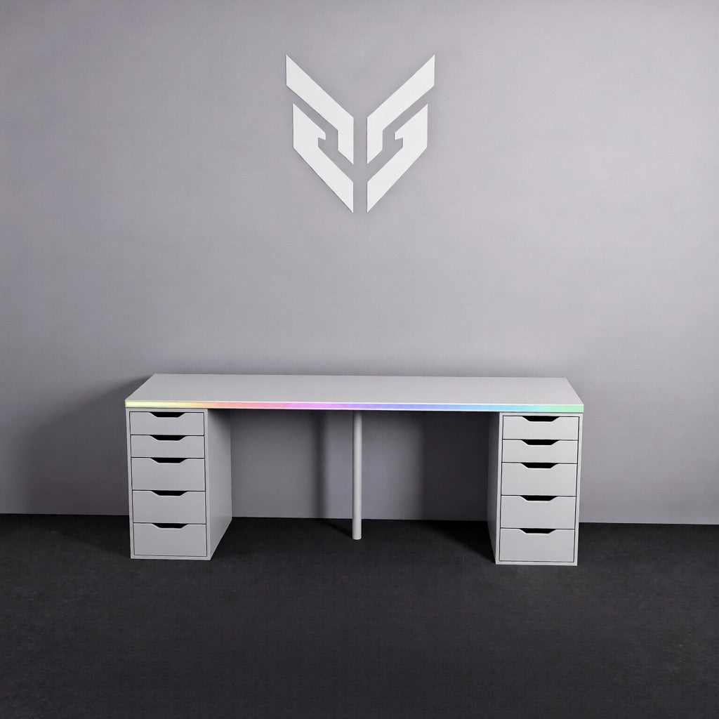 White computer desk with RGB lighting against a gray wall with a logo.